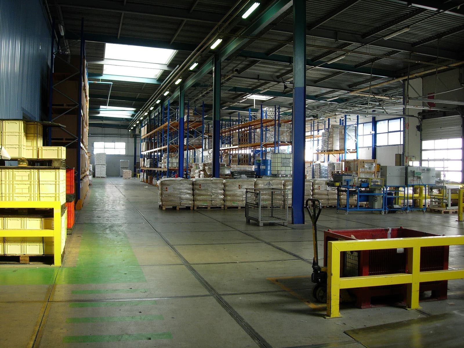Lorong gudang dengan pembatas pengaman berwarna kuning
